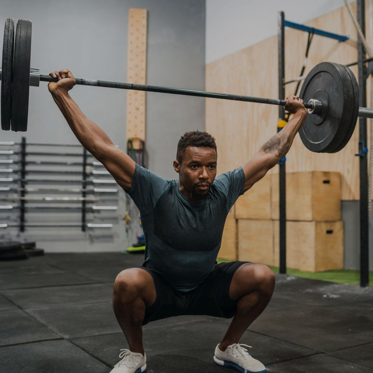 Person lifting a barbell in a gym setting